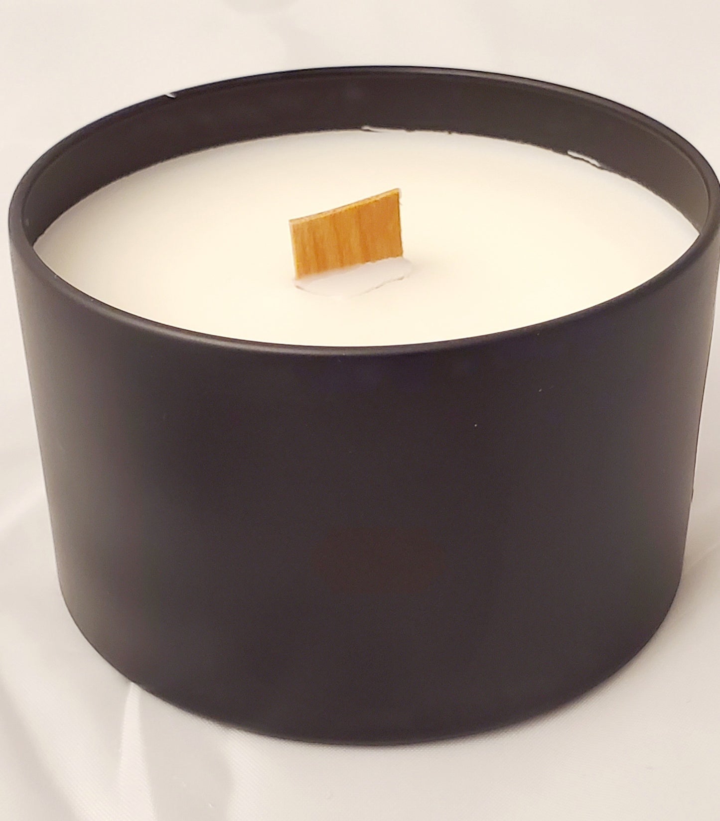 candle in black container with wood wick